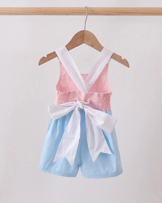 Pink top and blue shorts set with white trim on a hanger against a white background