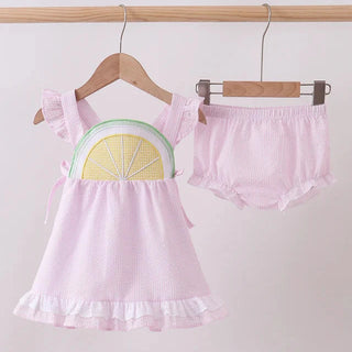 Pink children's outfit with a lemon design on a white background