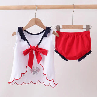 Children's outfit with white top and red shorts on hangers against a white background
