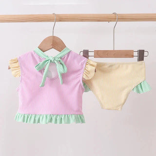 Children's pink and yellow striped outfit with ruffled details on a wooden hanger against a white background.