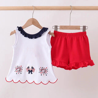 White tank top with ruffled sleeves and red shorts on hangers against a white background