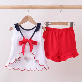 Children's outfit with white top and red shorts on hangers against a white background