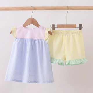 Children's top and shorts set hanging on a rack against a light background