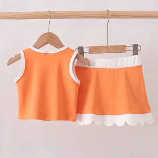 Orange tank top and skirt set on hangers against a light gray background