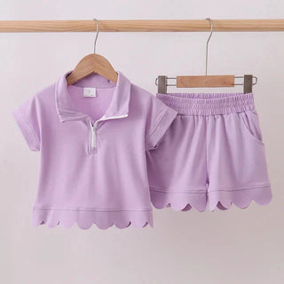 Lavender children's outfit with a shirt and shorts on hangers against a white background