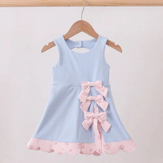 Light blue dress with pink accents on a wooden hanger against a white background