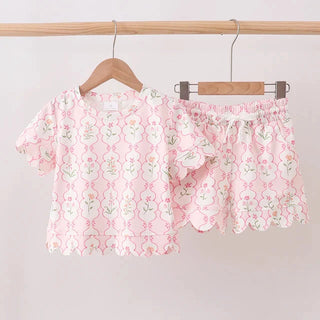 Pink floral outfit on hangers against a white background