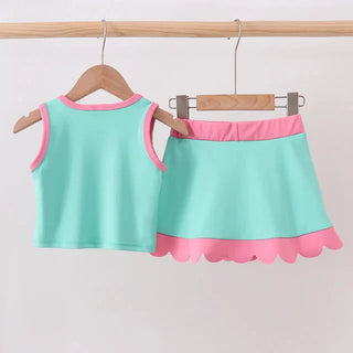 Children's outfit with a top and skirt on hangers against a light background