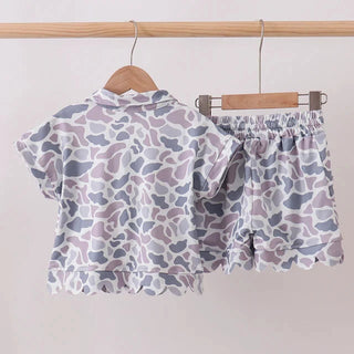 Children's outfit with a patterned shirt and shorts on a hanger against a white background