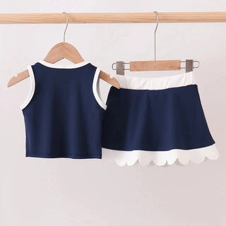 Navy blue top and skirt set on hangers against a light background