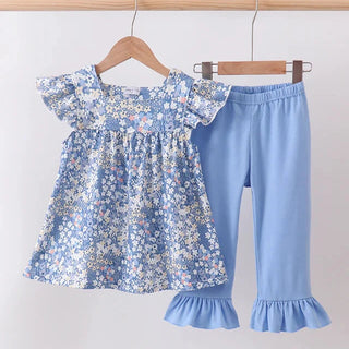 A toddler girl's two-piece clothing set hanging on wooden hangers against a plain light background. The set includes a light blue floral print short-sleeve top with ruffled sleeves and matching solid light blue cropped pants with ruffled hems.