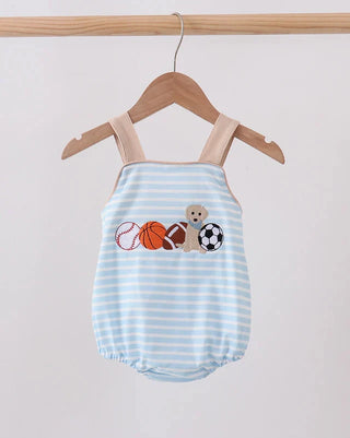 A baby romper with light blue and white horizontal stripes, featuring a graphic of sports balls and a teddy bear on the chest. The romper is displayed on a wooden hanger hanging from a wooden clothes rack against a plain light background.
