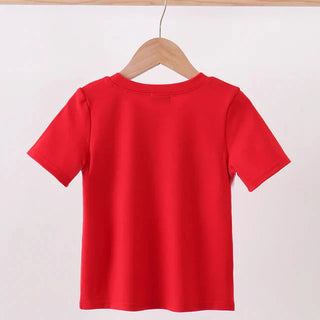 A bright red short-sleeve t-shirt hanging on a wooden hanger from a light wood clothing rack against a plain white wall.