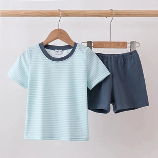 Light blue striped t-shirt and dark shorts on hangers against a plain background