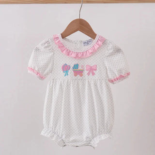 Baby romper with pink trim and embroidered design on a hanger against a light background