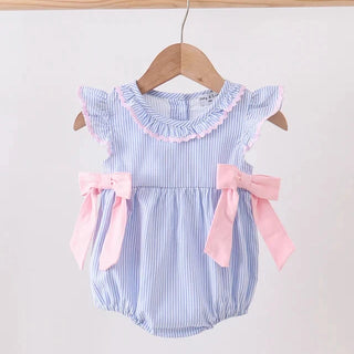 A baby girl's short-sleeve romper with light blue and white vertical stripes, featuring a pink ruffled collar, pink bow accents on the sides, and a wooden hanger hanging from a wooden rod against a plain light background.