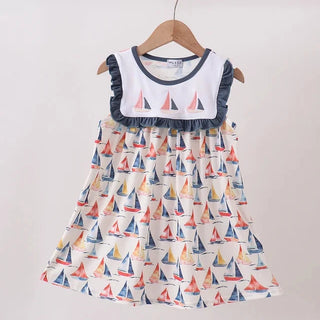 Children's dress with sailboat pattern on a hanger against a white background