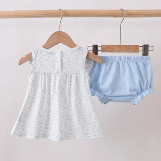 White floral dress and light blue bloomers on hangers against a white background