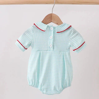 A baby romper in a light mint green and white gingham pattern with red piping trim on the collar and sleeve cuffs, hanging on a wooden hanger from a wooden clothes rack against a plain light background.