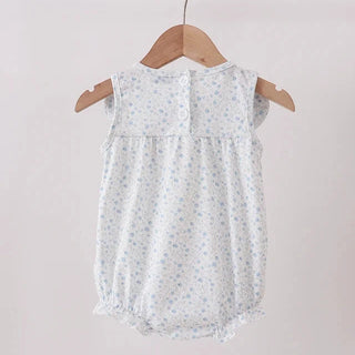 A sleeveless baby romper with a light blue and white floral pattern, hanging on a wooden hanger from a wooden clothes rack against a plain light background.
