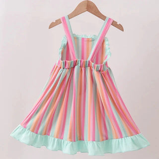 A sleeveless children's dress with vertical pastel stripes in pink, mint green, peach, and cream, featuring ruffled straps, a smocked bodice, and a ruffled hem, hanging on a wooden hanger against a plain light background.