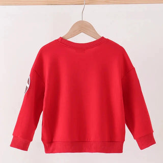 A bright red long-sleeve sweatshirt hanging on a wooden hanger from a light wood rod, shown against a plain off-white background.