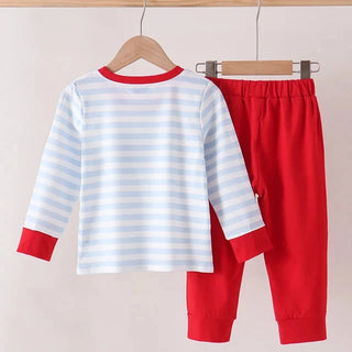 A two-piece children's pants set hanging on wooden hangers against a light beige wall. The set includes a long-sleeve top with white and light blue horizontal stripes, red collar, cuffs, and hem, paired with solid red pants.