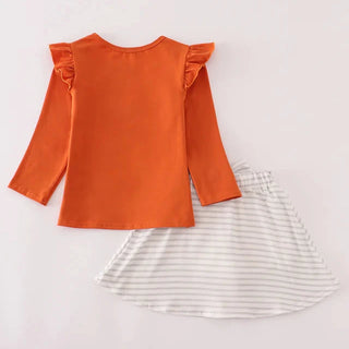 Orange top with ruffled shoulders and a striped skirt on a light gray background