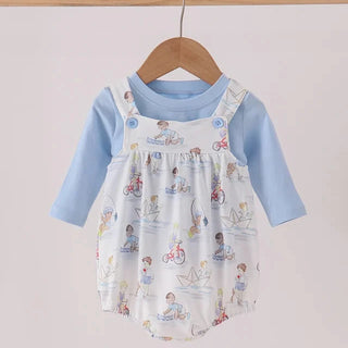A baby long-sleeve romper set hanging on a wooden hanger. The set features a light blue long-sleeve shirt underneath a white overall-style romper printed with small colorful cartoon children and nautical motifs.