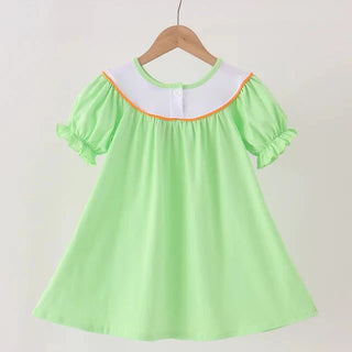 A light green short-sleeve dress with a white collar and thin orange trim, hanging on a wooden hanger against a plain light background.