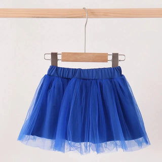 A bright blue tulle tutu skirt hanging from a wooden hanger on a clothing rack against a plain off-white background.