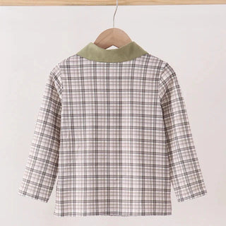A children's long-sleeve plaid shirt hanging on a wooden hanger against a plain light background. The shirt features a brown and beige plaid pattern with a contrasting sage green collar.