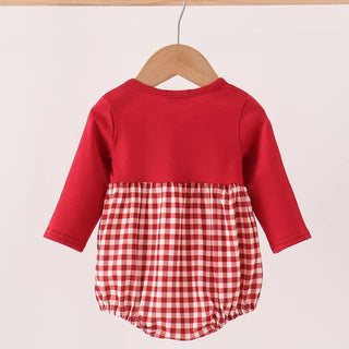 A baby long-sleeve romper hanging on a wooden hanger, featuring a solid red upper bodice and a red and white gingham checkered lower skirt, set against a plain light background.