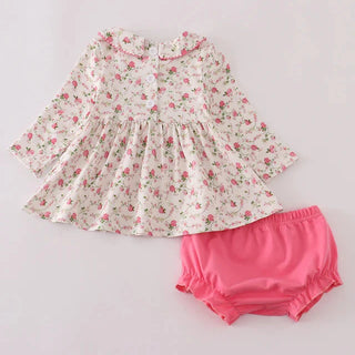 Floral dress and pink bloomers on a light gray background