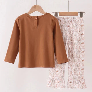 A two-piece children's outfit hanging on wooden hangers against a plain light background. The set includes a long-sleeve brown top with a button detail at the collar and matching flared pants in a pale pink and white patterned fabric.
