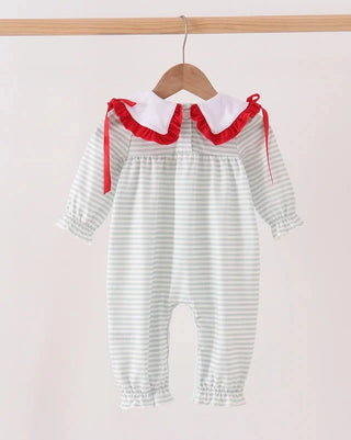 A baby romper with light green and white horizontal stripes, featuring a white Peter Pan collar with red ruffle trim and red side ties, hanging on a wooden hanger against a light beige background.