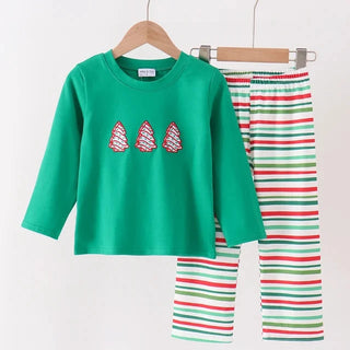 A children's two-piece holiday pajama set hanging on wooden hangers against a plain white wall. The set includes a bright green long-sleeve top with three red-and-white striped Christmas tree graphics on the chest, and matching striped pants with horizontal red, green, and white stripes.