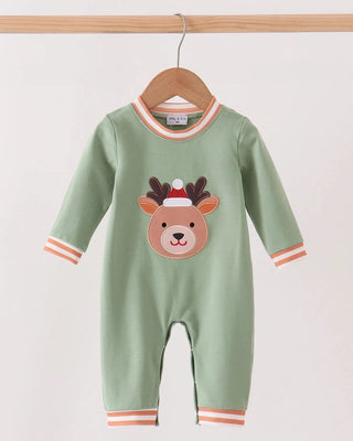A baby long-sleeve footless jumpsuit in sage green, hanging on a wooden hanger. The jumpsuit features an embroidered reindeer face on the chest wearing a Santa hat, with orange and white striped trim on the collar, cuffs, and hem.