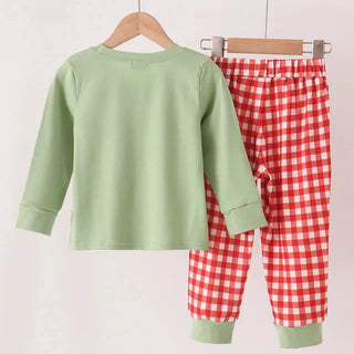 A two-piece children's pants set hanging on wooden hangers against a plain light background. The set includes a light sage green long-sleeve top and red-and-white gingham check pants with sage green cuffs.