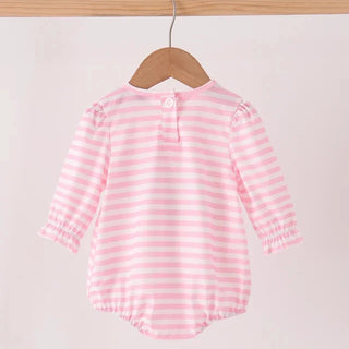 A baby long-sleeve romper with pink and white horizontal stripes, hanging on a wooden hanger from a light wood clothing rack against a plain off-white background.