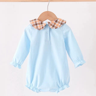 A baby long-sleeve romper in light blue, hanging on a wooden hanger. The romper features a contrasting plaid Peter Pan collar in brown, orange, and white, with a small button placket and ruffled trim at the cuffs and hem.