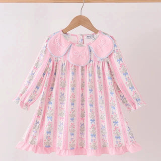 A pink long-sleeve girls dress with a floral pattern and a large embroidered Peter Pan collar, hanging on a wooden hanger against a plain light background.