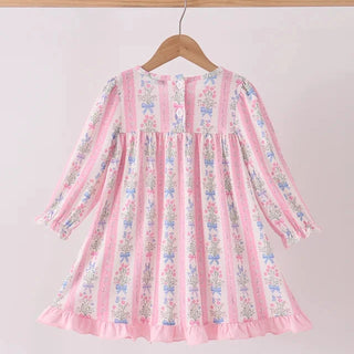 A pink long-sleeve girls dress with vertical stripes and delicate floral prints, hanging on a wooden hanger against a plain light background.