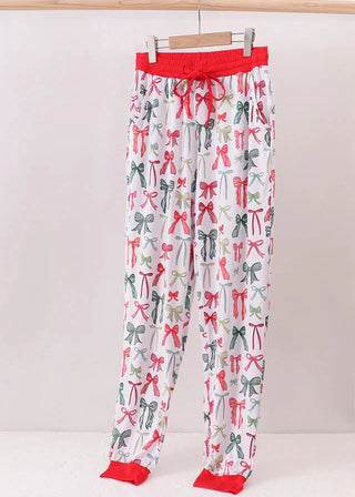 Pajama pants with bow pattern and red trim on a white background