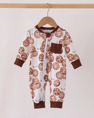 A baby long-sleeve footless romper hanging on a wooden hanger, featuring a white base with a brown and beige chocolate chip cookie print, brown cuffs, and a solid brown chest pocket.