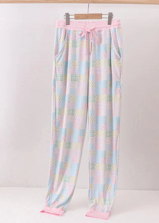 Pastel checkered pajama pants with pink trim on a white background