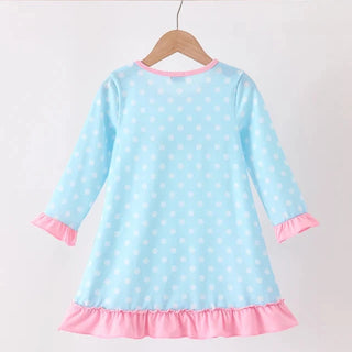 A light blue long-sleeve girl dress with white polka dots, pink ruffle trim at the cuffs and hem, hanging on a wooden hanger against a plain white background.