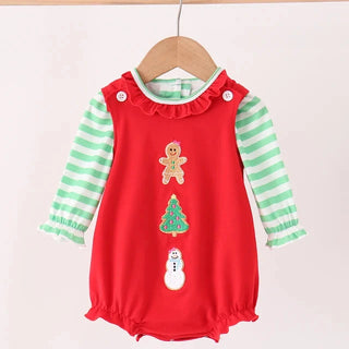 A baby romper with a red front panel featuring gingerbread man, Christmas tree, and snowman appliques, layered over mint green and white striped long sleeves, hanging on a wooden hanger.