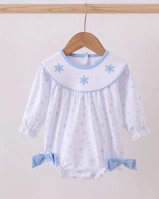 Baby romper with snowflake design on a wooden hanger against a white background