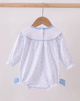 Baby romper with long sleeves and blue trim on a wooden hanger against a white background
